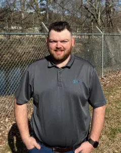 A photo of Josh Reid, standing outdoors and smiling